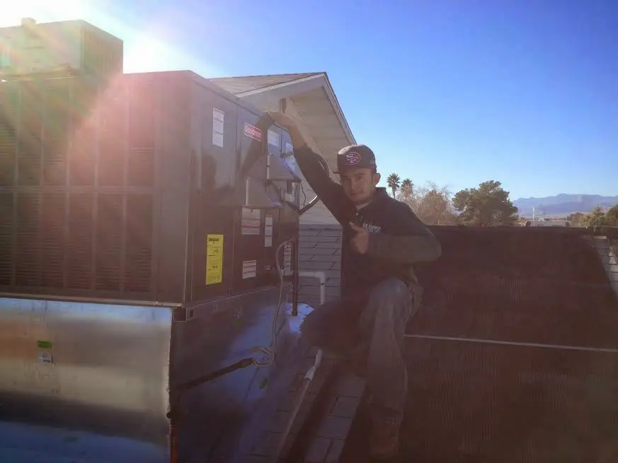 HVAC technician performing AC Tune-Up on a rooftop unit in Parker